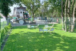 a park with chairs and a table and a playground at Hotel 77 Restauracja Spa in Chałupy