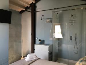 a bathroom with a glass shower and a bed at Giulia camere in Numana