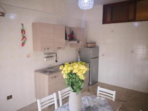 een keuken met een tafel met een vaas met gele bloemen bij House of Flowers in Pompei