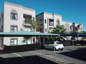 a car parked in front of a building with umbrellas at Serengeti Self Catering Units in Bellville