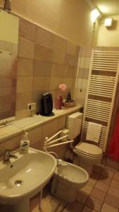 uma casa de banho com um lavatório, um WC e um lavatório. em Corte Posta B&B em Mantova