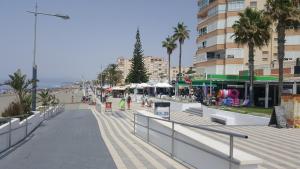 a city street with palm trees and a building at Canoa in Torrox Costa