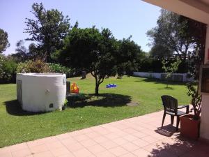 a yard with a table and a chair and a tree at White Sand Residence in Murta Maria