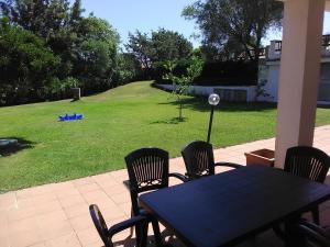 a table and chairs on a patio with a yard at White Sand Residence in Murta Maria