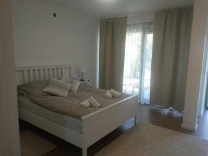 ein Schlafzimmer mit einem Bett mit Kissen und einem Fenster in der Unterkunft App Neno in Murine