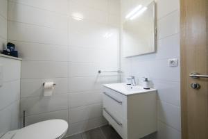 biała łazienka z toaletą i umywalką w obiekcie Apartmani Ujdur w Gradacu