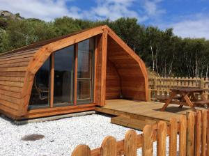 a large wooden cabin with a wooden deck at Achmelvich View self catering in Lochinver