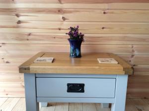 a table with a vase with flowers on it at Achmelvich View self catering in Lochinver