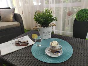 uma mesa com uma chávena de café e uma planta em Silver Apartman em Eger