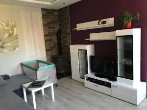 a living room with a flat screen tv and a couch at Karla iela in Ventspils