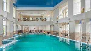 duży basen z niebieską wodą w budynku w obiekcie TES-Hotel Resort & Spa w mieście Eupatoria