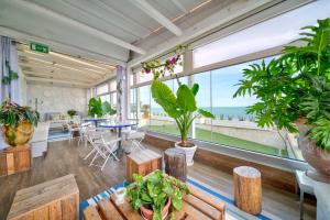 a room with plants and tables and a large window at Hotel Select Suites & Spa - Apartments in Riccione