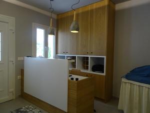 eine Küche mit einer weißen Theke und Holzschränken in der Unterkunft Galini Hellenic Hospitality in Patitiri