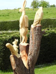 a statue of rabbits on a tree stump at Camping les Tournesols in Sillé-le-Guillaume