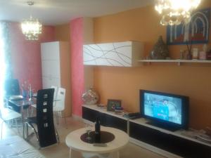 - un salon avec une télévision et une table dans l'établissement Residencial Algaida, à Oropesa del Mar