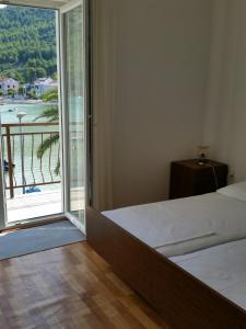 ジュリャナにあるVukotić Beach houseのベッドルーム1室(ベッド1台付)、景色を望むバルコニーが備わります。