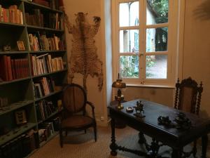 a room with a table and a window and book shelves at La maison des pères in Charolles