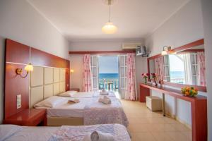 Agoulos Beach Hotel في أرغاسي: غرفة نوم بسريرين وإطلالة على المحيط