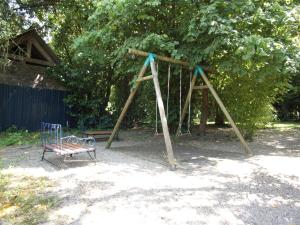 a swing set in a park with a bench at Try-Logis in Plerguer