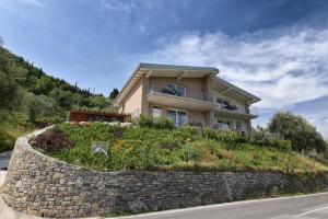a house on a hill with a stone wall at Casa negli Ulivi in Tremosine Sul Garda