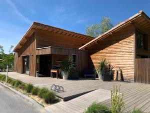 a wooden building with a table and chairs in front of it at Chalet 3 chambres en Bois dans les landes n37 in Tosse