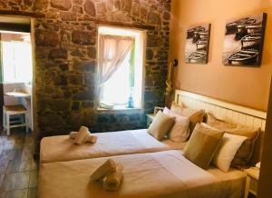 two beds in a room with a window at Axiokersa Suites in Samothráki