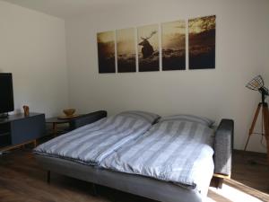 a bedroom with a bed with four pictures on the wall at Ferienwohnung Ponlach in Tittmoning