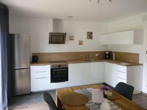 a kitchen with white cabinets and a wooden table at Ferienwohnung Ponlach in Tittmoning
