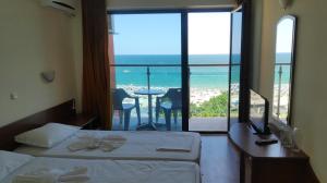 Cette chambre d'hôtel comprend un lit et offre une vue sur l'océan. dans l'établissement Hotel Shipka Beach - Free parking, à Sunny Beach