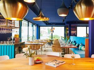 un restaurant avec une table et des chaises ainsi qu'un bar dans l'établissement New Wave, à Norderney