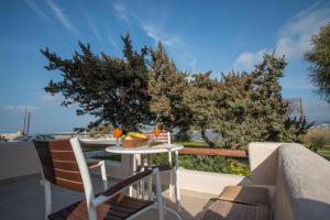 einen Tisch und Stühle auf einem Balkon mit Meerblick in der Unterkunft Gratsias Luxury Apartments Naxos in Stelida