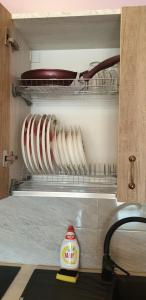 斯文托伊Vieno aukšto kotedžas的带架子的橱柜，上面放着一些餐具