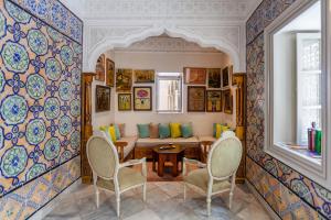 a dining room with a table and chairs and a wall covered in tiles at Dar El Jeld Hotel and Spa in Tunis