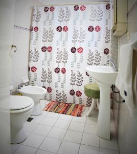 a bathroom with a toilet and a shower curtain at Las Acacias De Santa Rosa in Santa Rosa