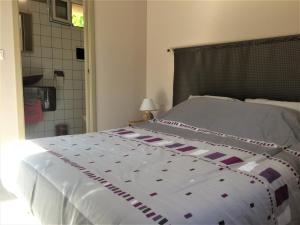 ein Schlafzimmer mit einem großen Bett mit einer weißen Bettdecke in der Unterkunft Les deux chemins in Mons