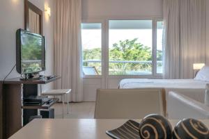 um quarto de hotel com uma cama e uma televisão em Valeria Playa Apart em Valeria del Mar