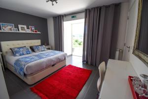 a bedroom with a bed and a red rug at Casa nas Serras in Vila Nova de Poiares
