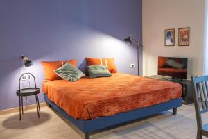 een slaapkamer met een groot bed en een oranje deken bij Casa Diverio in Stresa