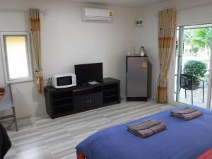 a bedroom with a bed and a microwave and a tv at Canachri Resort in Ban Thung Pho