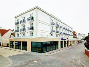 a large white building on a city street at New Wave in Norderney