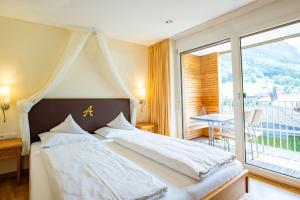 a bedroom with a bed and a large window at Allegra Wohlfühl Appartements in Brand