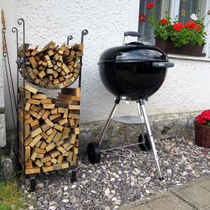 a grill sitting next to a pile of fire wood at Penzion ALENA in Pec pod Sněžkou