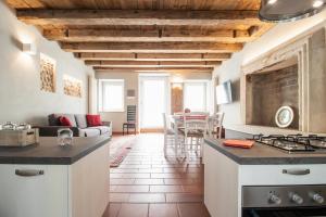 a kitchen and living room with wooden ceilings and a table at Bossema Luxury Countryhouse in Cavaion Veronese