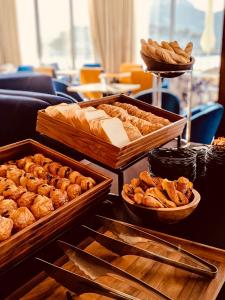 a table topped with trays of bread and pastries at Hôtel Les Roches Blanches Cassis in Cassis
