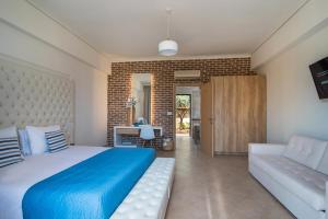 a bedroom with a blue bed and a couch at Kahlua Bay Apartments in Hersonissos