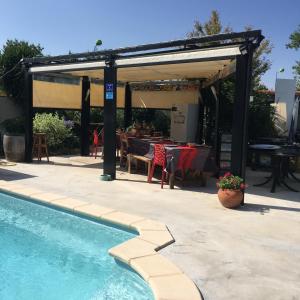 een patio met een zwembad en een tafel en stoelen bij Happy House St Cyp in Saint-Cyprien