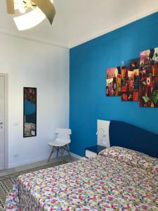 a bedroom with a bed and a blue wall at LA DIMORA SICILIANA APPARTAMENTI in Trapani