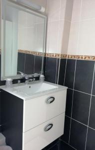 a bathroom with a white sink and a mirror at Le Terminus fasthotel soissons centre in Soissons