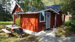 Un hangar rouge avec une table de pique-nique devant lui dans l'établissement Sollyan, à Knivsta