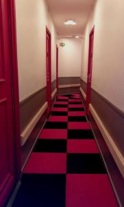 a hallway with a red and black checkered floor at Le Terminus fasthotel soissons centre in Soissons